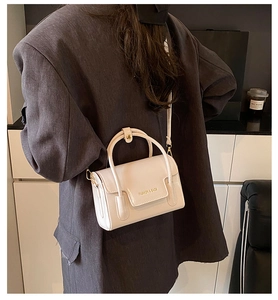Détail du mini sac carré en cuir ciré crème avec poignée et finitions dorées