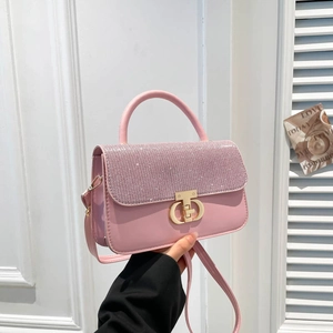 Pink leather handbag with rhinestone flap and gold CD buckle shown in elegant setting