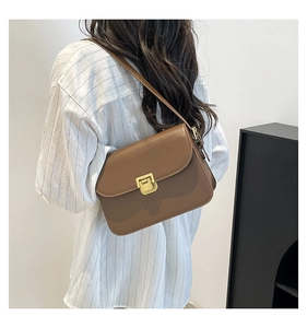 Vue arrière d'une femme portant un petit sac carré marron rétro avec fermoir doré