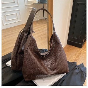 Detailed mirror view of large brown woven leather tote bag with fashion tag detail
