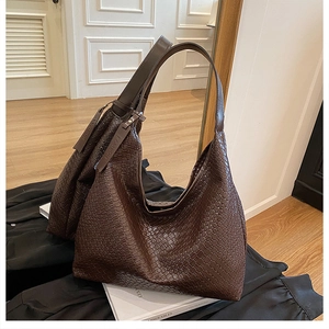 Detail of dark brown woven hobo bag showing leather texture and fashion tag decoration