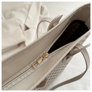 Détail du tissage du sac cabas avec fermeture éclair en métal et écusson triangle