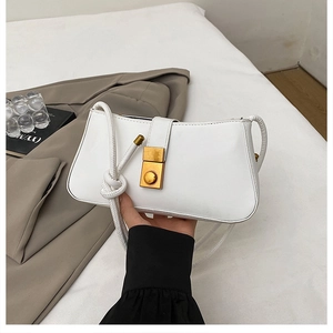 Detail view of white PU leather baguette bag featuring a gold buckle and knotted strap detail