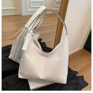 Detailed close-up of a white woven leather Hobo bag with texture and fashion tag