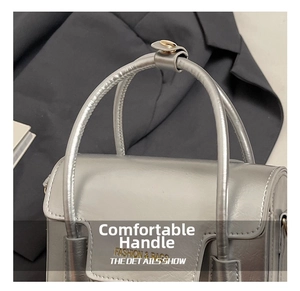 Gros plan sur la poignée argentée et la boucle métallique d'un sac à main vintage