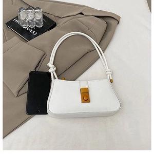 Detail of white faux leather underarm bag with unique knot handle and gold buckle