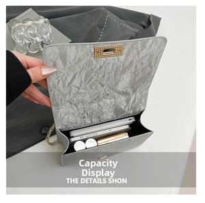 Detailed interior capacity showing space for two phones and makeup in the silver crossbody bag