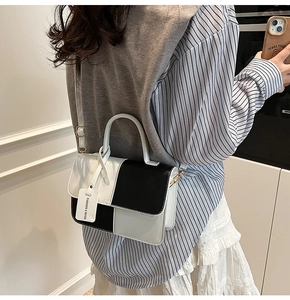 Detail of a chic black and white color-block crossbody bag with adjustable shoulder strap