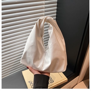 Detail of white pleated handle tote bag with soft PU material and knot design