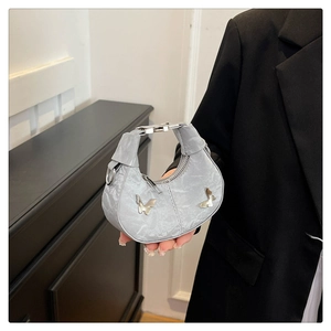 Détail du mini sac croissant gris avec papillons métalliques et texture plissée