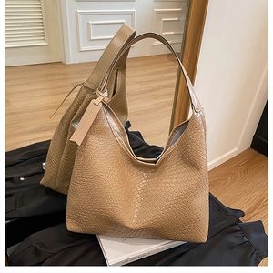 Detailed weave pattern on khaki woven hobo bag with a decorative fashion tag