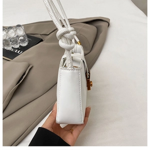 Detail of white PU leather square bag with knotted shoulder strap and precise stitching