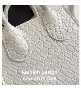 Detailed close-up of woven texture and premium stitching on a white crossbody bag