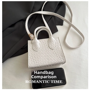Detail of white woven texture mini bag with gold hardware and removable shoulder strap