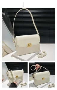 Détail d'un sac bandoulière en cuir blanc crème avec fermoir doré et doubles sangles