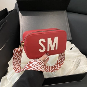 Sac bandoulière rouge avec patch SM blanc et large sangle tissée géométrique