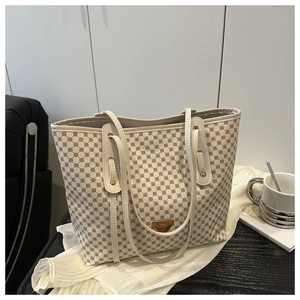 Détail du sac cabas crème avec motif monogramme marron et logo métallique triangulaire
