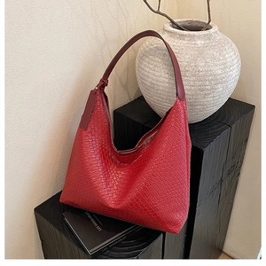 Close-up of red woven leather tote bag texture on dark aesthetic display stand