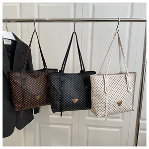 Détail de grands sacs cabas en trois couleurs suspendus dans une ambiance de boutique