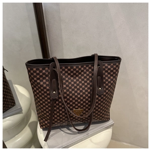 Détail du motif monogramme géométrique et du logo en métal sur le sac cabas