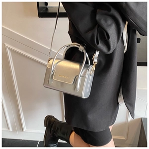 Détail du sac à main argenté métallisé avec texture lisse et poignée élégante