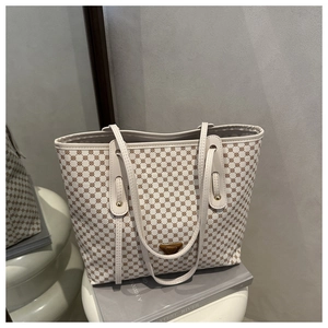 Détail du grand cabas beige avec imprimé cercles bruns et plaque logo en métal rétro