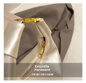 Detail showing the polished gold metal buckle and premium cream leather texture