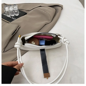 Interior view of a white leather baguette bag showing storage space for daily essentials