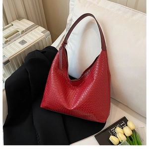 Detail of red woven texture on hobo shoulder bag with fashion pendant accessory