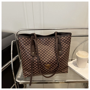 Détail macro du grand sac cabas avec motif géométrique marron et plaque logo métallique