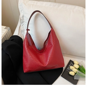 Detail of red woven leather hobo bag with Fashion tag resting on a cozy cushion