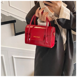 Détail d'un sac carré en cuir verni rouge avec lettrage doré Fashion & Bags