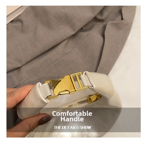Close-up of creamy white glossy dumpling bag featuring a golden metal buckle and zipper