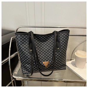 Vue détaillée du grand sac cabas avec motif géométrique bleu et plaque de logo dorée