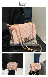 Close-up of pink leather crossbody bag with V-quilt stitching and gold chain strap