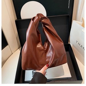 Detailansicht einer dunkelbraunen Ledertasche mit einzigartigem geknotetem Griff
