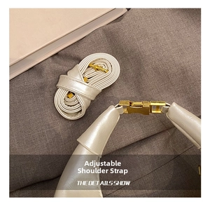 Detail of adjustable cream leather shoulder strap with premium gold metal buckle for handbag