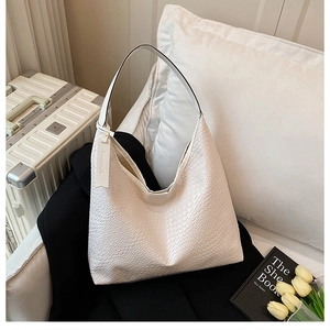 Close-up of white woven tote bag with animal skin texture and fashion tag detail