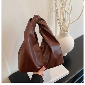 Detailansicht der dunkelbraunen Falten-Eimertasche mit minimalistischem Knotengriff