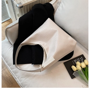Detail of white woven hobo bag with fashion tag against stylish minimalist background
