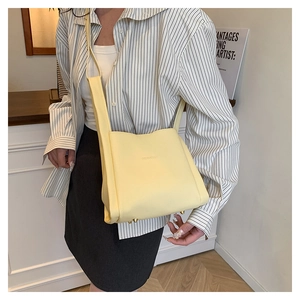 Detail of light yellow lychee grain leather bucket bag with protective bottom rivets