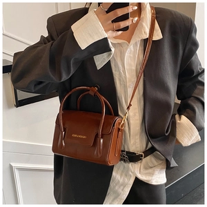 Selfie miroir d'un sac à main en cuir marron brillant avec bandoulière et lettrage doré