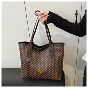 Détail d'un grand sac cabas avec texture géométrique marron et logo triangulaire
