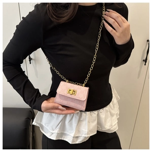 Detailed view of pink micro chain bag with gold twist-lock and fine metallic strap