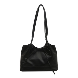 Minimalist black faux leather tote bag with thin bow detail and sturdy wide base design