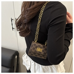 Miniature brown single shoulder bag with M-pattern jacquard and gold chain strap on model