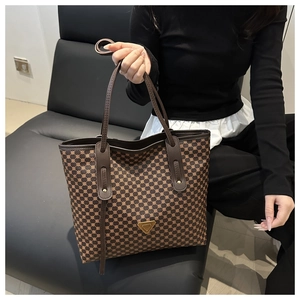 Détail du grand sac cabas marron foncé avec motifs géométriques et plaque logo dorée