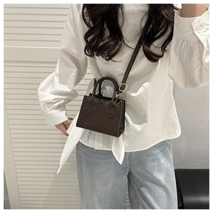 Detailed view of dark brown woven texture mini crossbody bag with delicate strap