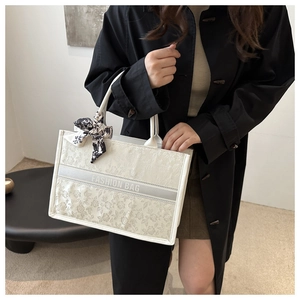 Detail of white floral tote bag with silk scarf and Fashion Bag text on center strap
