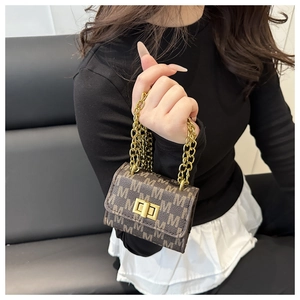 Macro view of mini dark brown chain bag with M-pattern print and golden twist lock